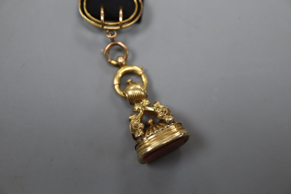 A Victorian yellow metal overlaid and carnelian set fob seal, with 9ct mounted ribbon sash with bale, seal 27mm,